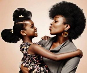 Mère tête crépue montre à sa fille tète crépue comme elles sont belles avec leur cheveux au naturel.